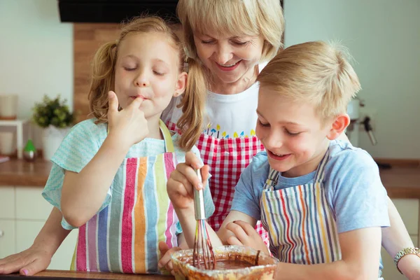 快乐的祖母与她的孙子在烘烤松饼和曲奇饼期间乐趣 — 图库照片