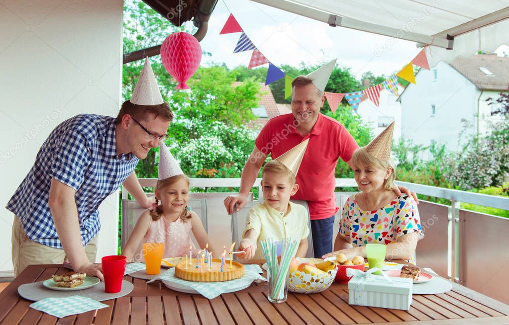 Colorful portrait of happy big family celebrate birthday and grandparents blows candles with their children 