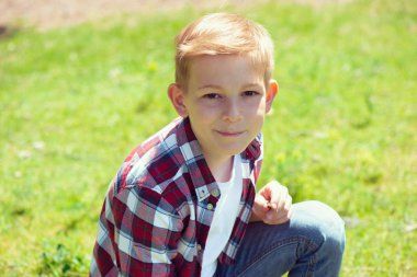 Okul bahçesinde ekose gömlekli çekici bir gencin portresi.