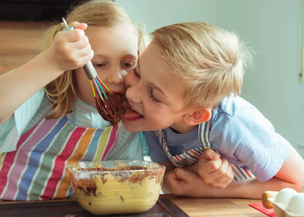 两个快乐的孩子在现代厨房的烤松饼中享受巧克力面团的乐趣和味道 — 图库照片