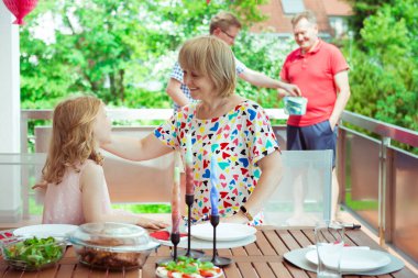 Mutlu büyük bir aile eğleniyor ve terrasse adlı ızgara sırasında konuşmalarını çocuk ve torun ile keyfini çıkarın