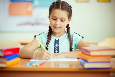 Ders sırasında okulda sevimli gülümseyen kız öğrenci portresi