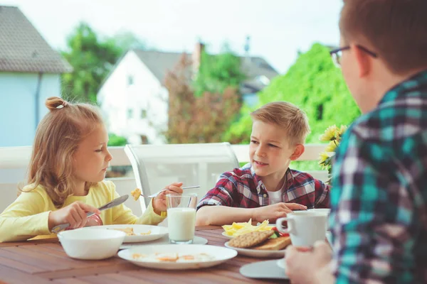 幸せな若い家族が家の大きなテラスで朝食中に楽しんでいます — ストック写真