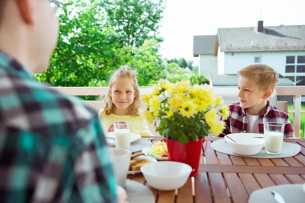 快乐的年轻家庭在家里的大阳台上吃早餐的时候玩得很开心 — 图库照片