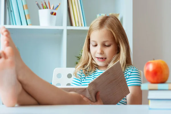 Porträtt Rolig Liten Skolflicka Avkopplande Läser Bok Bordet Ljus Rum — Stockfoto