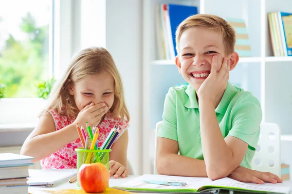 かわいい小学生が学校に戻ってきて 教室でテーブルで学習 — ストック写真