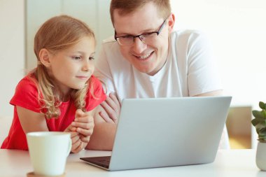 Mutlu genç Baba iyi eğlenceler oldukça küçük kızıyla laptop ile modern evde çalışma sırasında