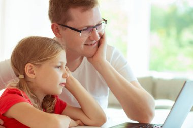Mutlu genç Baba iyi eğlenceler oldukça küçük kızıyla laptop ile modern evde çalışma sırasında