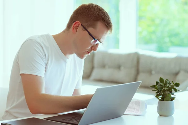 Молодой Красивый Мужчина Работает Дома Своим Ноутбуком — стоковое фото