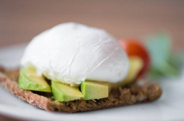 Yeşil salata ve avokado ile kepekli ekmek tost ve benedict ile sağlıklı kahvaltı yumurta