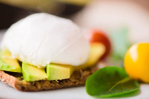 グリーン サラダとアボカドと卵の全粒粉パン トースト ベネディクトと健康的な朝食 — ストック写真