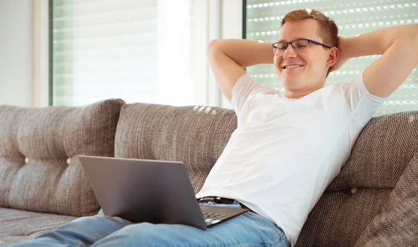 Jonge man aan het werk met laptop thuis — Stockfoto