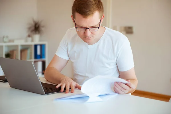 Mladý muž pracující s přenosným počítačem doma — Stock fotografie