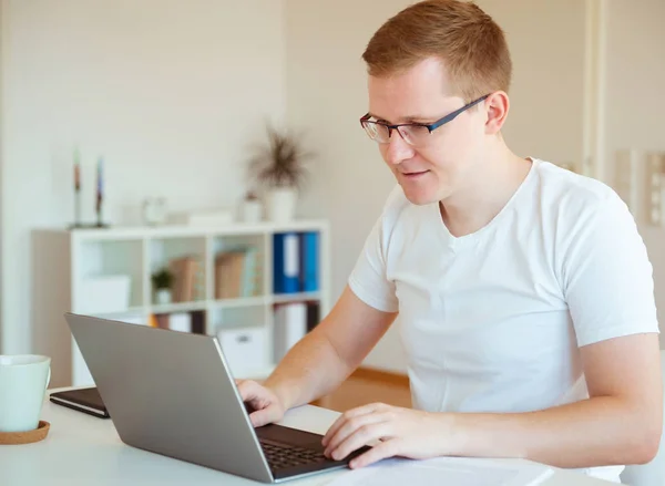 Jovem trabalhando com laptop em casa — Fotografia de Stock