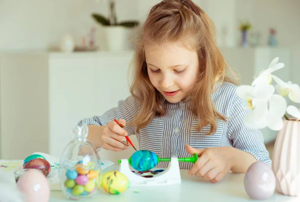 Cute little blonde girl painting Easter eggs — Stock Photo, Image