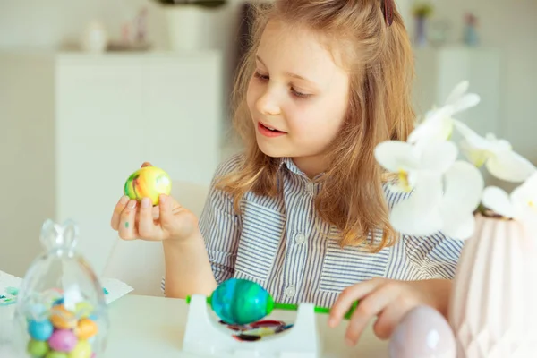 Linda niña rubia pintando huevos de Pascua —  Fotos de Stock