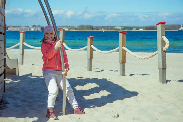 Adorable niña jugando en el patio de recreo en una playa — Foto de Stock