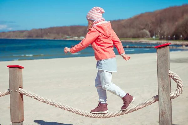 Adorável menina brincando no playground em uma praia — Fotografia de Stock