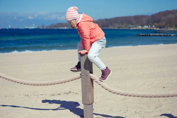 Adorable niña jugando en el patio de recreo en una playa — Foto de Stock