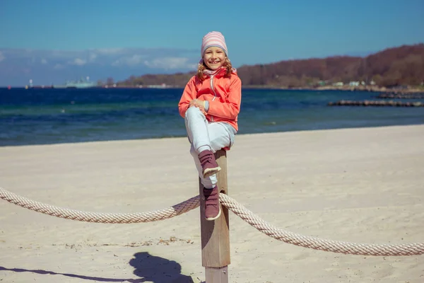 Очаровательная девочка играет на детской площадке на пляже — стоковое фото