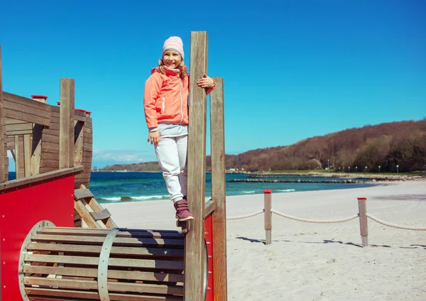 Чарівна маленька дівчинка грає на ігровому майданчику на пляжі — стокове фото