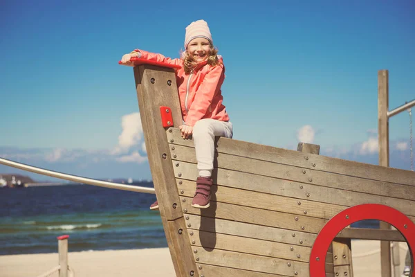 Entzückendes kleines Mädchen spielt auf einem Spielplatz am Strand — Stockfoto