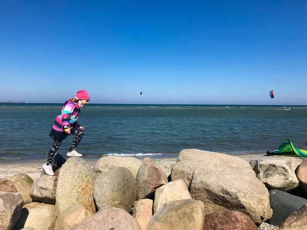 Niños felices caminando y buscando deportes acuáticos en una playa — Foto de Stock