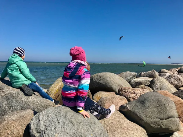 Niños felices caminando y buscando deportes acuáticos en una playa — Foto de Stock