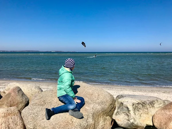 Niños felices caminando y buscando deportes acuáticos en una playa — Foto de Stock