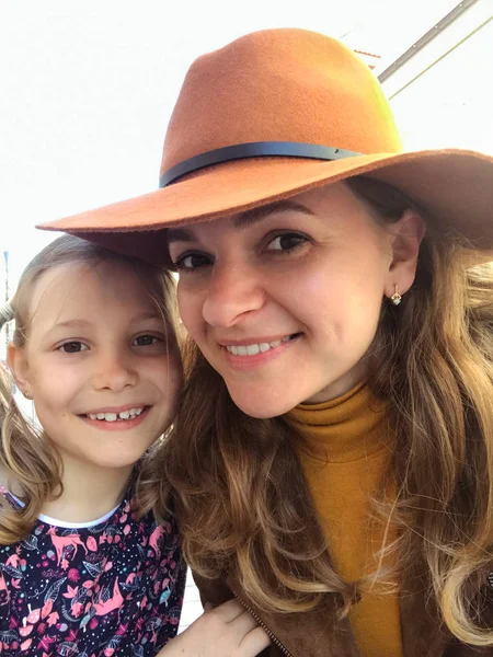 Sonrientes madre e hija mirando a la cámara — Foto de Stock