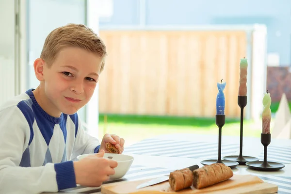 Guapo adolescente comiendo sopa y pan de grano entero en li brillante —  Fotos de Stock