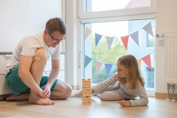 Giovane padre felice che gioca con la sua figlia carina con bl di legno — Foto Stock