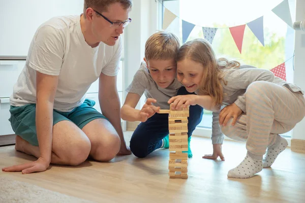 Giovane padre felice giocare con i suoi due bambini carini con woode — Foto Stock