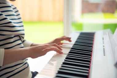 Genç çocuk evde e-piyano ile eğitim kursu var