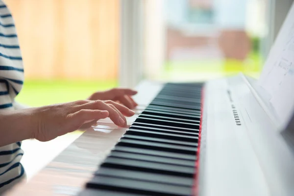 Adolescente chico tiene curso de formación con e-piano en casa —  Fotos de Stock