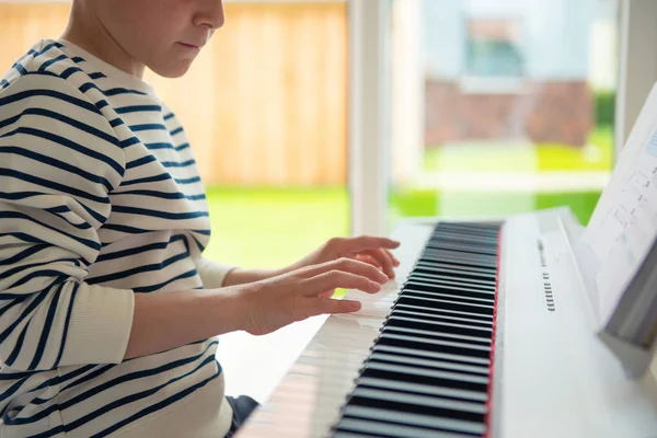 Teenager má trénink s e-klavírem doma — Stock fotografie