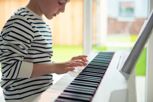 Adolescente menino tem curso de formação com e-piano em casa — Fotografia de Stock