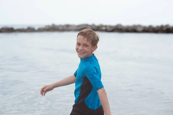 Portret van knappe tiener jongen rennen in neopreen badpak in se — Stockfoto