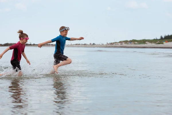 ネオプレンの水着遊びで2人の幸せな兄弟の子供たちと — ストック写真