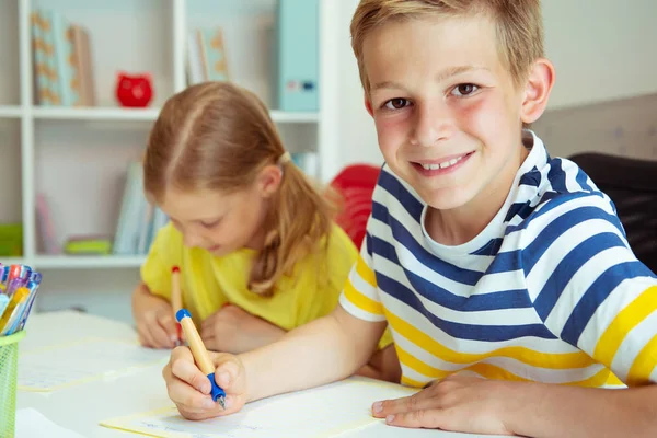 Skolbarn kommer tillbaka till skolan och lär sig vid bordet — Stockfoto