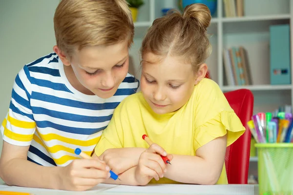 Skolbarn kommer tillbaka till skolan och lär sig vid bordet — Stockfoto