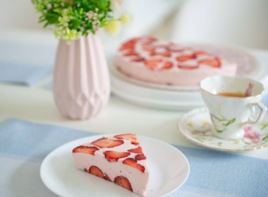 Bir masada çilek ile Taze cheesecake