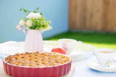 Taze pişmiş elmalı turta, bir masada çay ve çiçek fincan 
