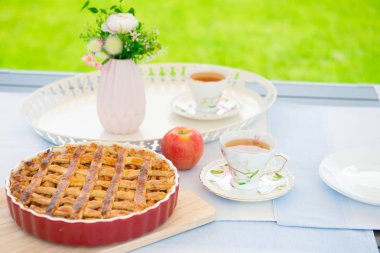 Taze pişmiş elmalı turta, bir masada çay ve çiçek fincan 
