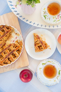 Taze pişmiş elmalı turta, bir masada çay ve çiçek fincan 
