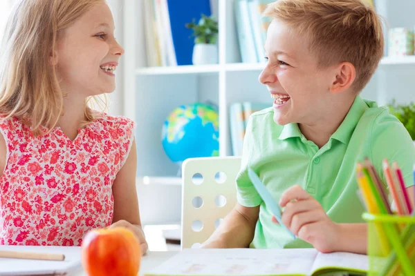 Skolbarn kommer tillbaka till skolan och lär sig vid bordet — Stockfoto