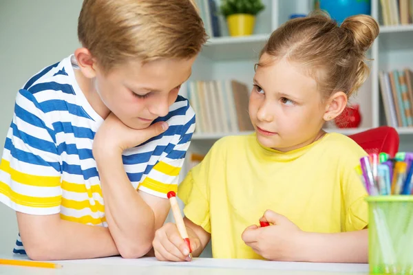 Skolbarn kommer tillbaka till skolan och lär sig vid bordet — Stockfoto