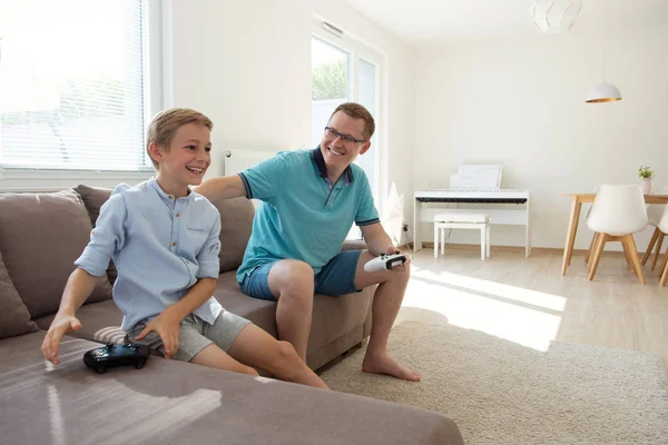 Happy young father and  his son playing computer games  with con — Stock Photo, Image