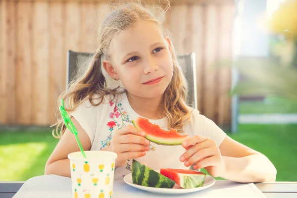 Портрет счастливой маленькой девочки, поедающей сладкий красный арбуз — стоковое фото