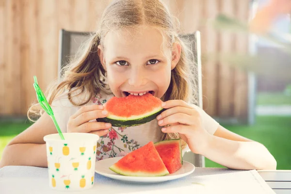 Tatlı kırmızı karpuz yiyen mutlu sevimli küçük kız Portresi — Stok fotoğraf